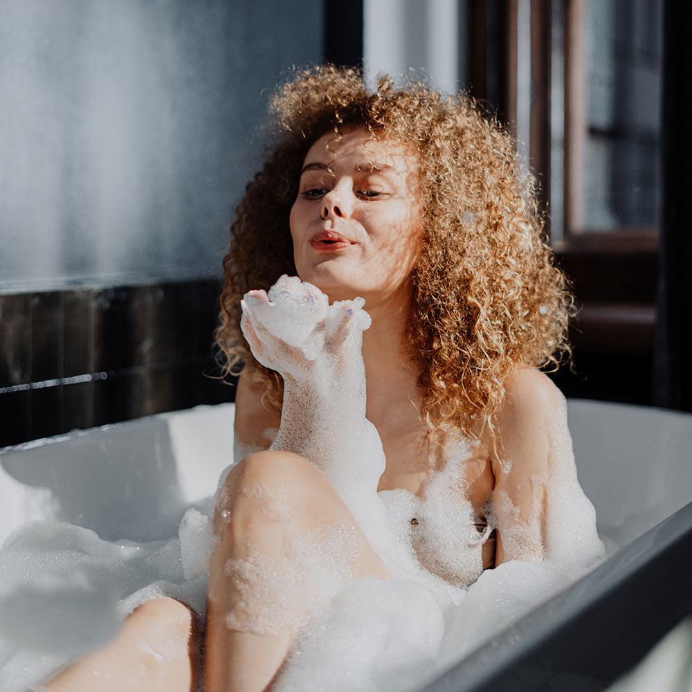 Woman in bath using Mumu Bath Signature Hydrating Facial Soap